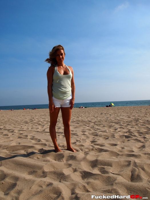 Возбужденная стройняшка в белоснежном бикини показывает свою красоту на песке, показывая лучшие части тела